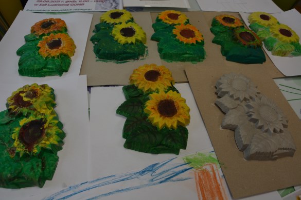 Pomalowane odlewy gispowe słoneczników wykonane przez dzieci na zajęciach plastycznych