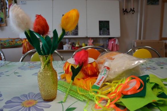 Na zdjęciu gotowe tulipany w szklanym wazoniku oraz materiały potrzebne do ich wykonania.